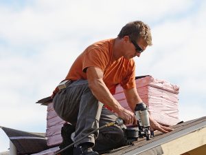 Male contractor installing roofing.